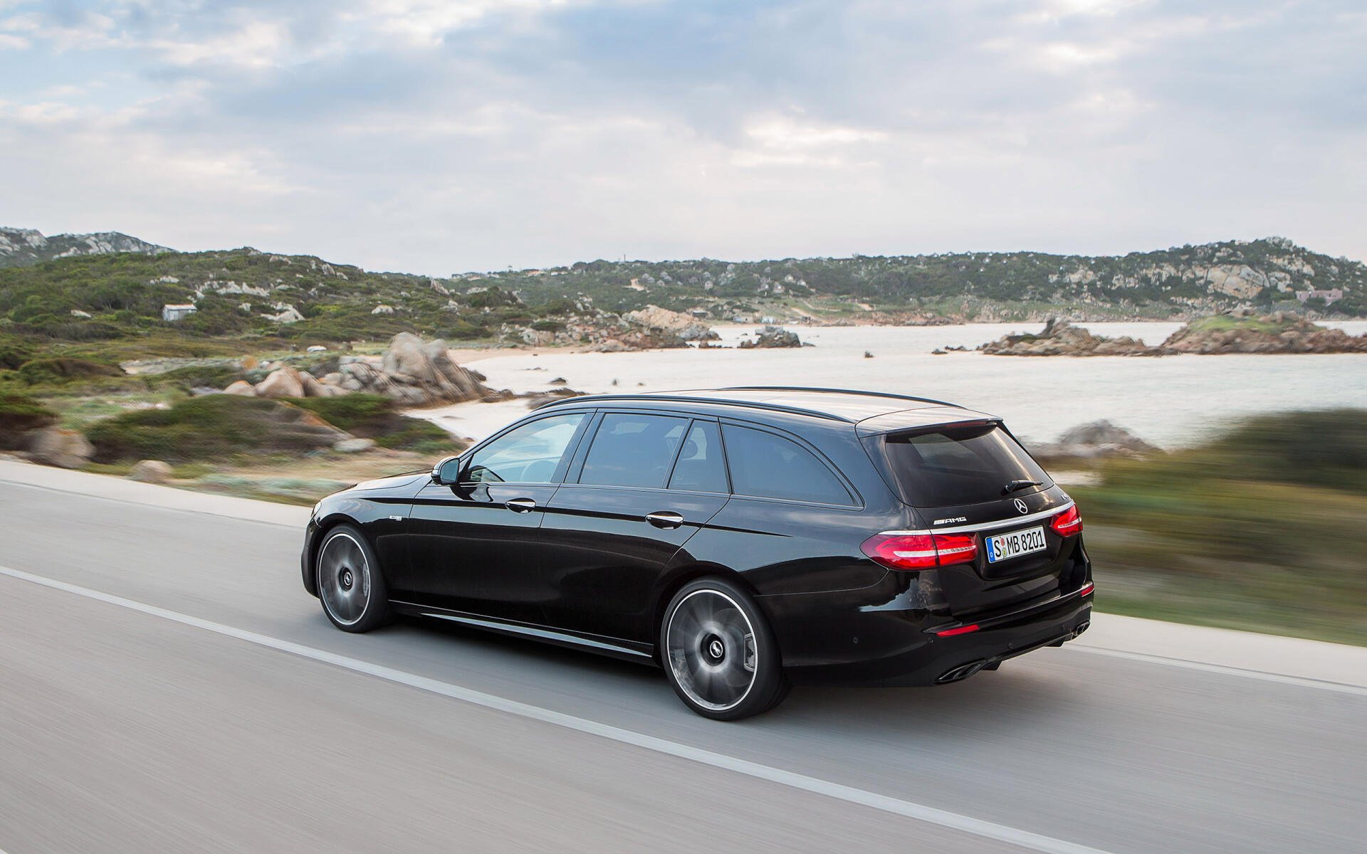 A high-definition desktop wallpaper featuring a sleek Mercedes-Benz E43 AMG, showcasing the luxury and performance of the Mercedes-Benz AMG lineup.