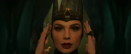 A woman in a dark crown and dramatic makeup poses, evoking the character from the movie Snow White (2025). The image serves as an HD desktop wallpaper and background.