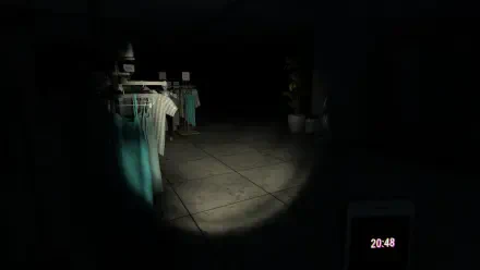 A dimly lit interior featuring clothing racks against a dark background, showcasing a scene from the video game Mannequin (2024). A flashlight beam adds a sense of suspense.
