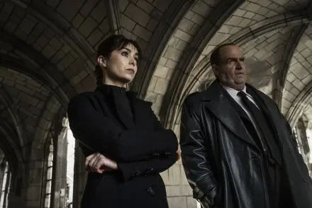 A dramatic scene from the TV show The Penguin featuring Cristin Milioti and Colin Farrell, set against a gothic architectural backdrop, showcasing intense expressions and strong characters.