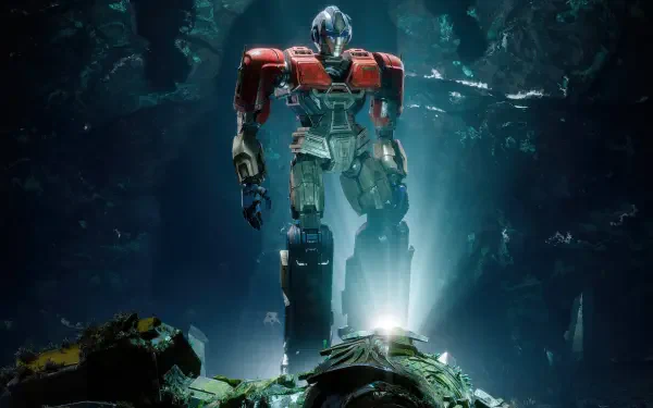 Transformers One 2K Quad HD PC desktop wallpaper — a towering red-and-blue Autobot stands illuminated in a dark, ruined cavern above smashed machinery.