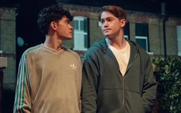 Two young men stand closely together in a nighttime setting, gazing into each other's eyes, capturing a tender moment from the TV show Heartstopper, set as a 4K Ultra HD desktop wallpaper.