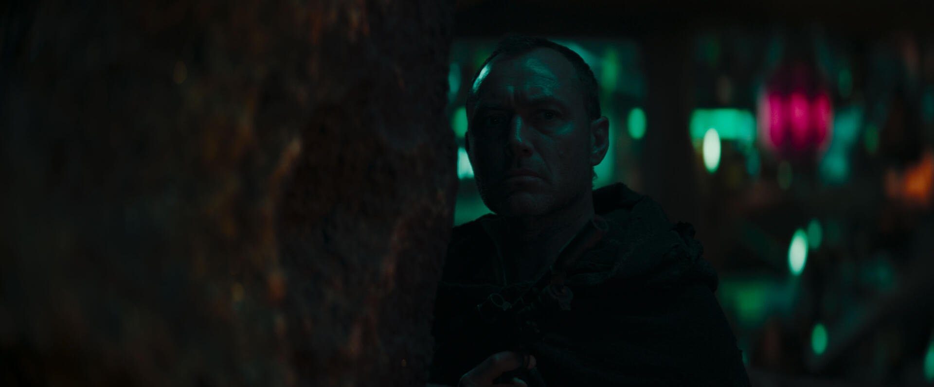 Jude Law appears in a moody scene from the Star Wars: Skeleton Crew TV show, set against a visually dynamic backdrop. A captivating HD desktop wallpaper.