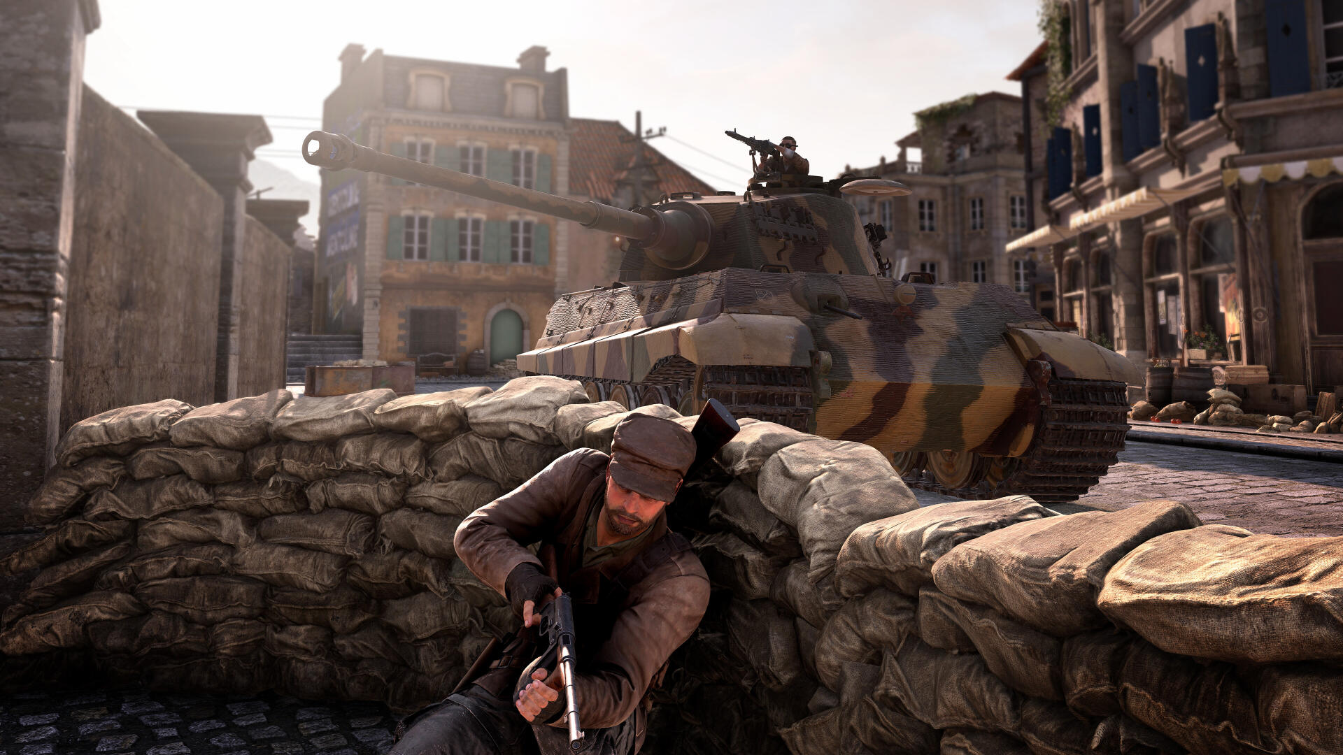 A soldier takes cover behind a barricade as a tank looms in the background, capturing a tense moment from Sniper Elite: Resistance in stunning 4K Ultra HD.
