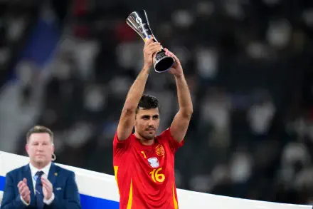 Rodri Hernández of the Spain National Football Team triumphantly holds the trophy aloft, celebrating a significant victory in this dynamic 4K Ultra HD soccer image.