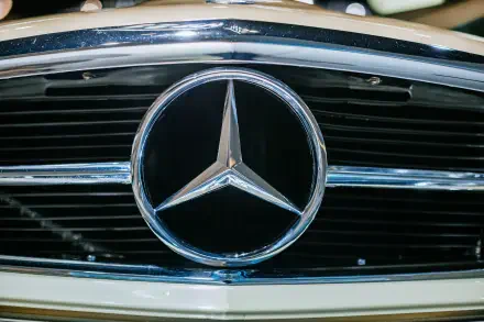 Close-up of the Mercedes-Benz logo on the front grille of a classic Mercedes-Benz 230 SL, showcased in vibrant 4K Ultra HD quality.