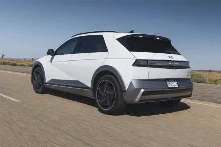 A sleek Hyundai IONIQ 5 drives on an open road under a clear blue sky, showcasing its modern design in this 4K Ultra HD desktop wallpaper.