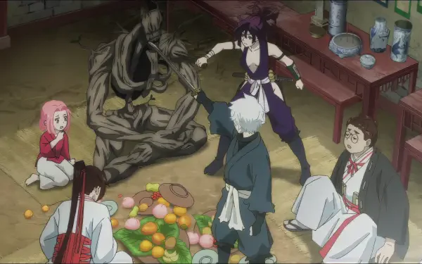 A scene from Hell's Paradise featuring Gabimaru and others in a dynamic moment. The characters interact around a spread of colorful fruits in a rustic setting.