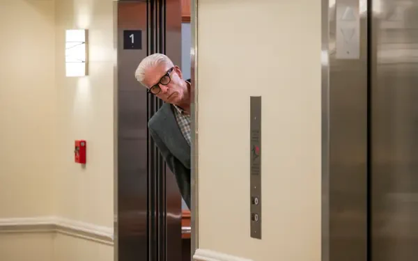 A scene from the TV show A Man on the Inside features Ted Danson peeking out from an elevator, adding a touch of intrigue to this HD desktop wallpaper.