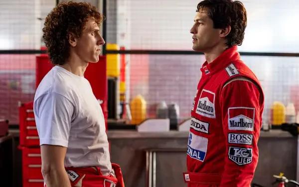 A dynamic scene from the TV show Senna (2024) featuring Ayrton Senna and another character, set in a racing garage, showcasing intense rivalry and emotion.