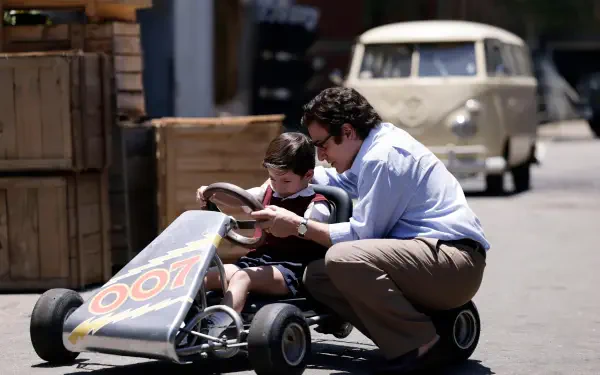 A scene from the TV show Senna (2024), featuring a man and a young boy working on a go-kart in a lively outdoor setting, capturing a moment of connection and joy. 8K Ultra HD quality.
