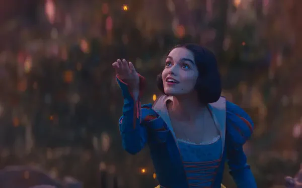 Rachel Zegler as Snow White in a vibrant scene from the 2025 movie. The image captures her expression of wonder against a magical background filled with soft lights.