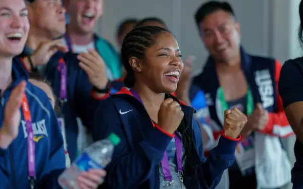 A vibrant scene from The Fire Inside featuring Ryan Destiny, showcasing joyful celebration among a group, capturing the excitement and camaraderie in 4K Ultra HD.