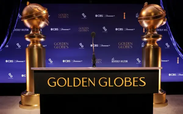 A sleek HD desktop wallpaper featuring the Golden Globe Awards stage, showcasing iconic golden globes flanking a podium with GOLDEN GLOBES prominently displayed.