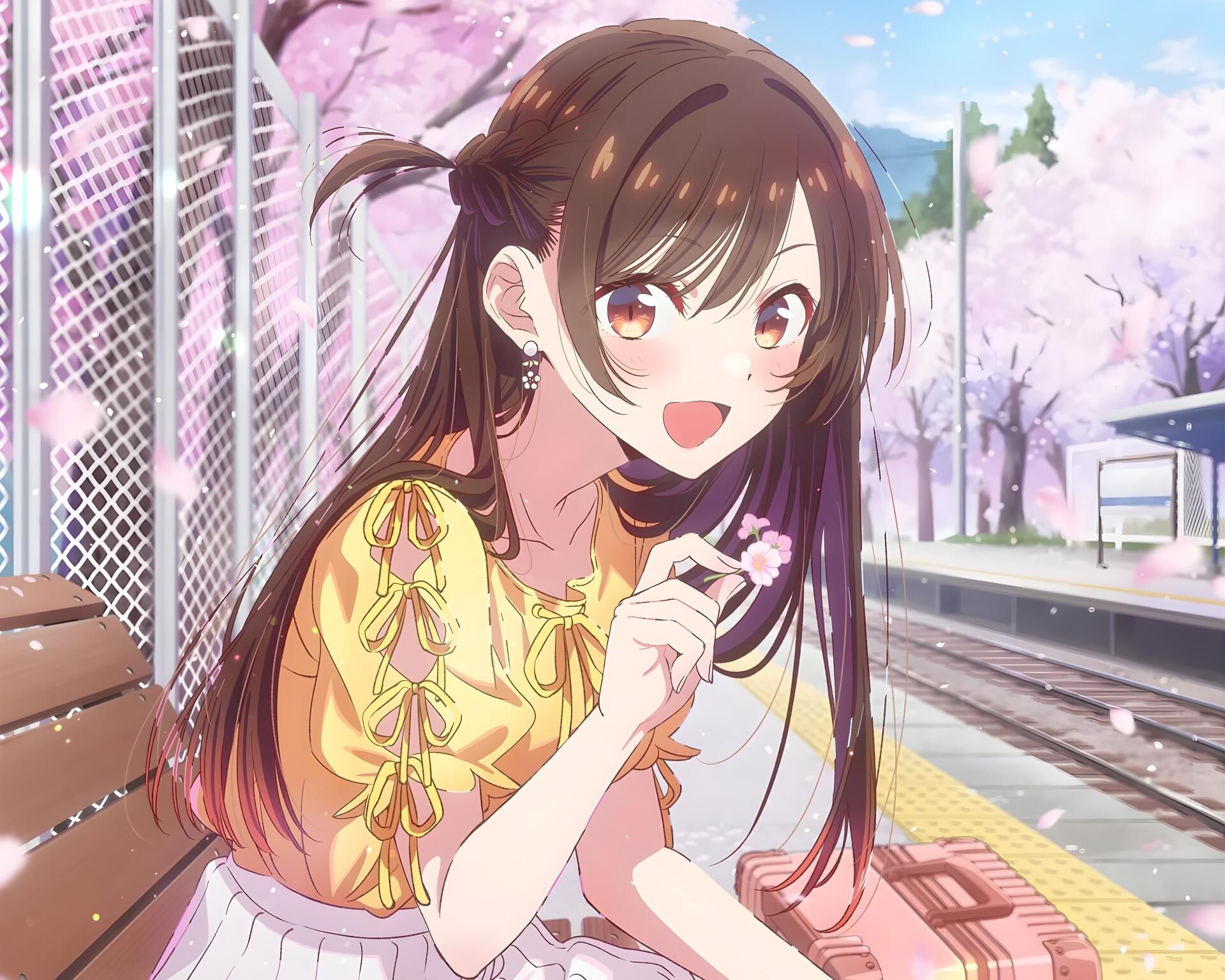 Anime 5K Ultra HD PC desktop wallpaper/background of Chizuru Ichinose from Rent-A-Girlfriend smiling on a sunlit train platform, holding a snack amid falling cherry blossoms.