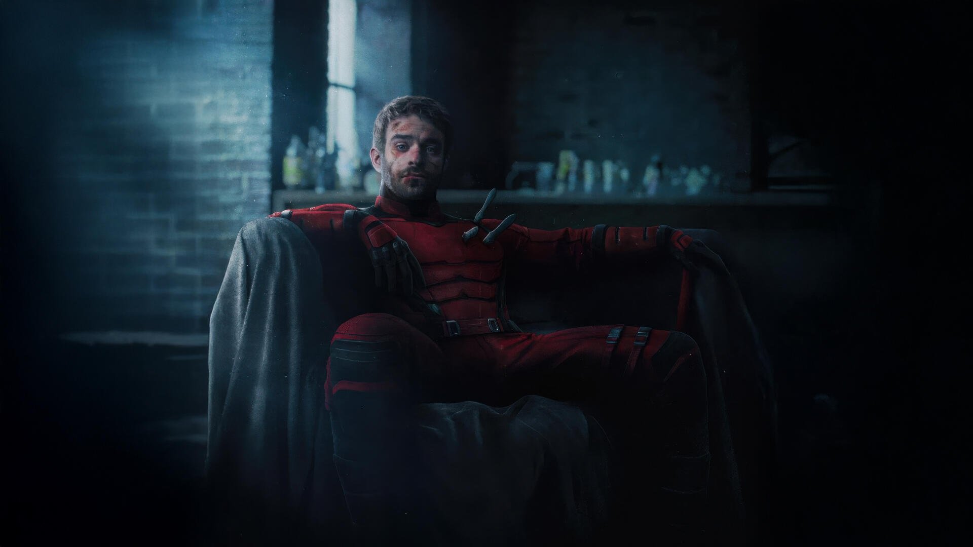 Daredevil: Born Again — 4K Ultra HD PC desktop wallpaper of Daredevil in his red suit seated on a shadowy armchair in a dim, moody urban room.
