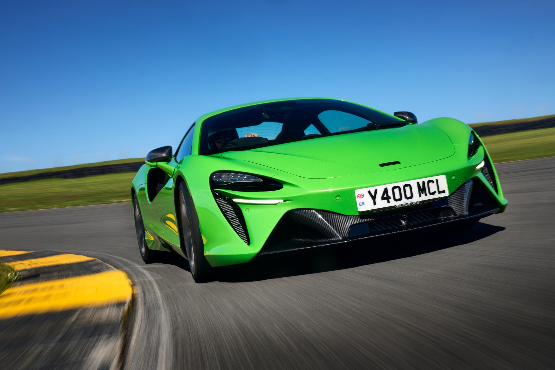 A vibrant green McLaren Artura racing on a track, showcased in stunning 8K Ultra HD, captures the essence of performance and luxury.