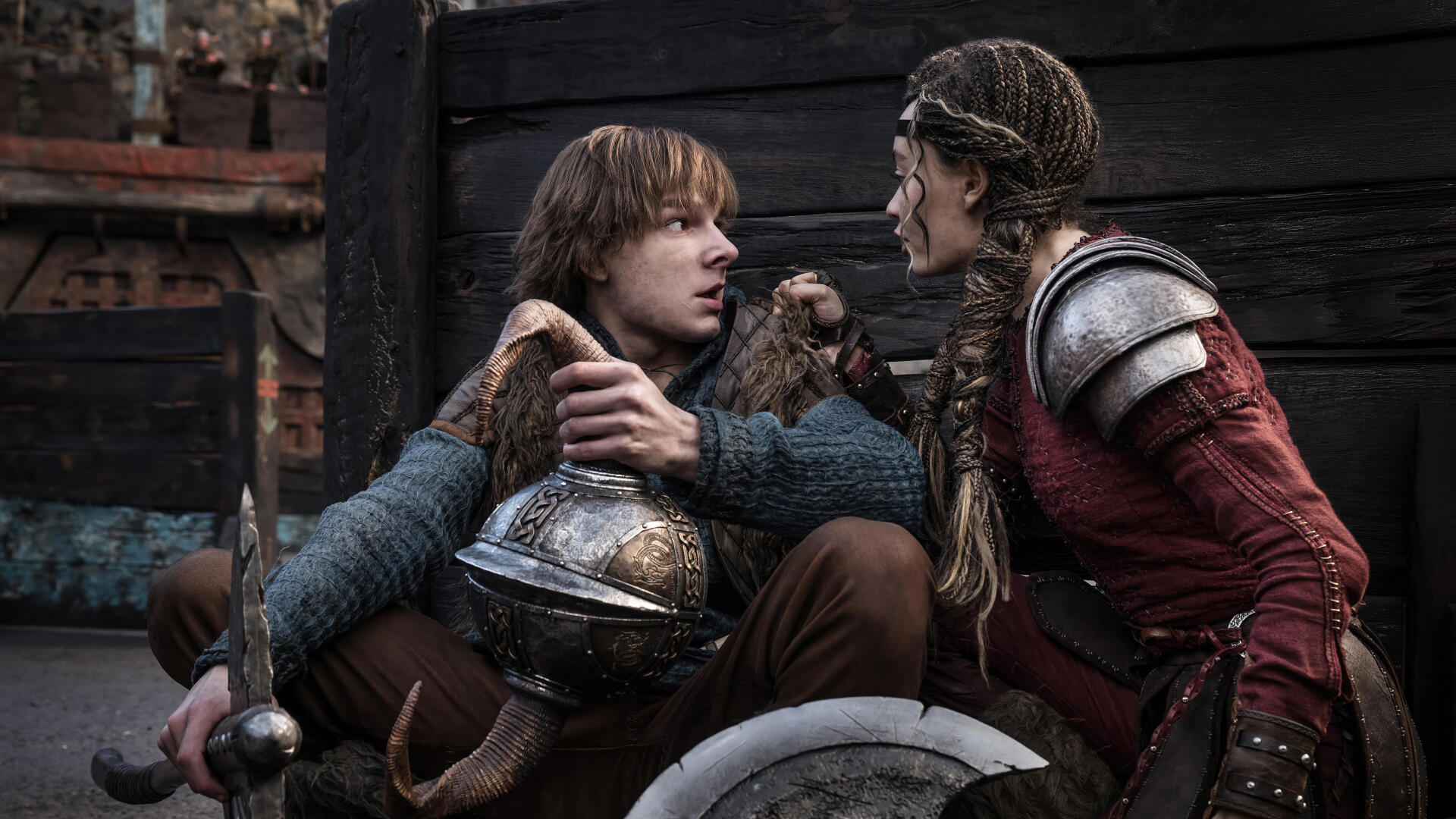 Hiccup and a warrior engage in a tense moment, surrounded by a rugged backdrop, in this 4K Ultra HD wallpaper from the upcoming movie How to Train Your Dragon (2025).