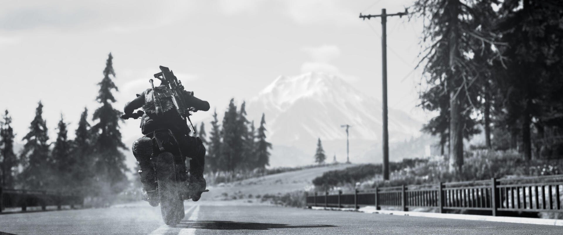 A black and white scene from the video game Days Gone, featuring a rider on a motorcycle kicking up dirt on a remote road with mountains in the background. 4K Ultra HD wallpaper.