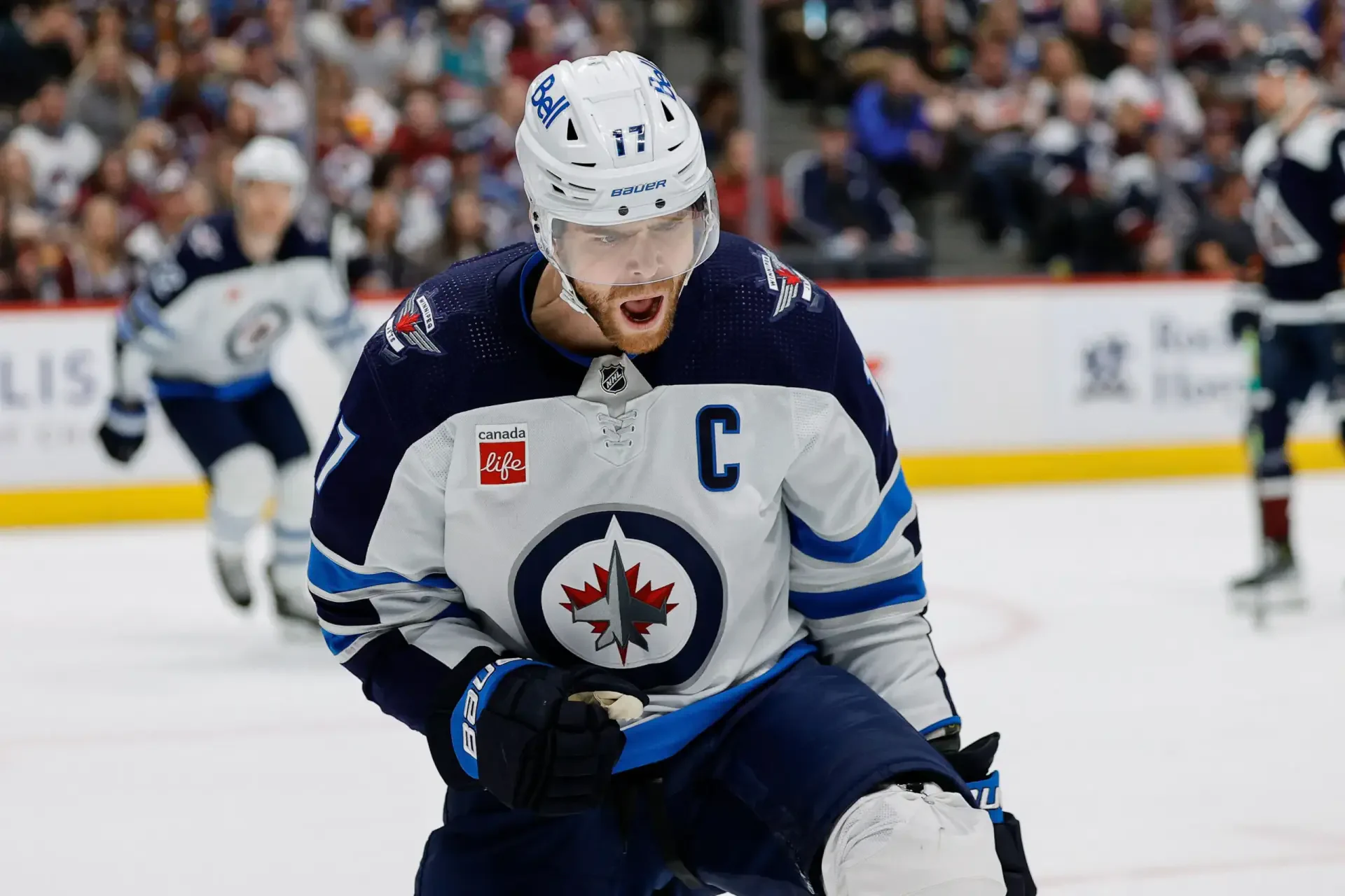 HD hockey wallpaper featuring a Winnipeg Jets NHL player in action on the ice during a game, showcasing intense sportsmanship and team spirit.