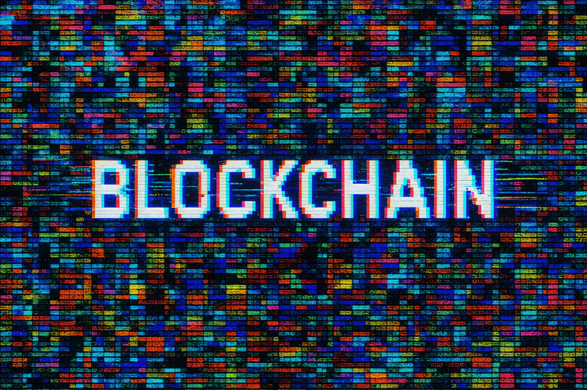 4K Ultra HD desktop wallpaper featuring the word BLOCKCHAIN in bold white text over a vibrant, colorful digital matrix background.