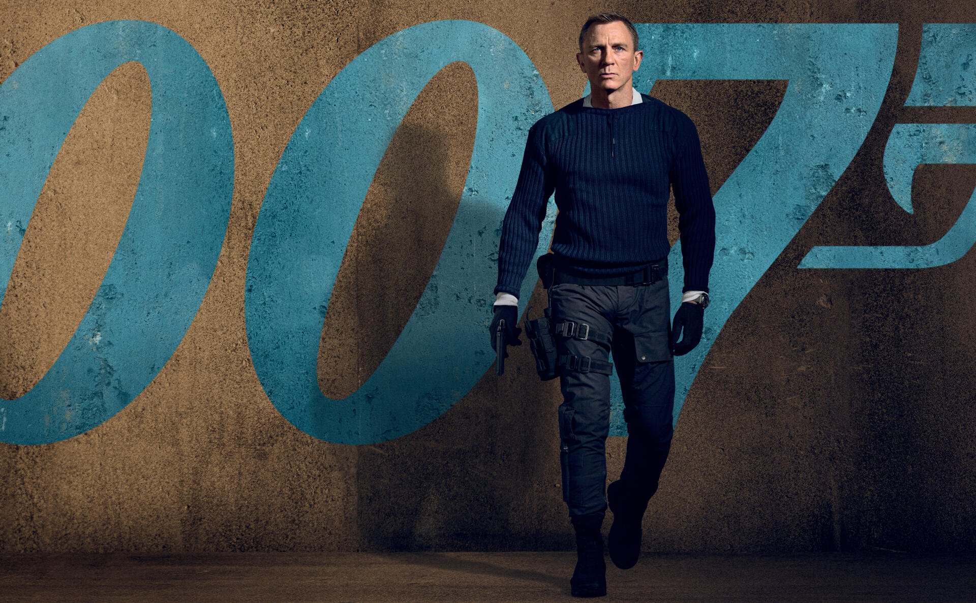 No Time to Die 4K Ultra HD PC desktop wallpaper/background: a lone man in a navy sweater and tactical pants walks before a large blue '007' emblem on a textured concrete wall.