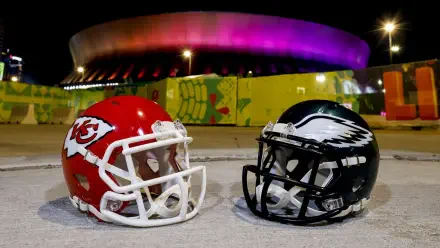 A vibrant HD wallpaper featuring Kansas City Chiefs and Philadelphia Eagles football helmets, set against a backdrop of an illuminated stadium, capturing the excitement of NFL sports.
