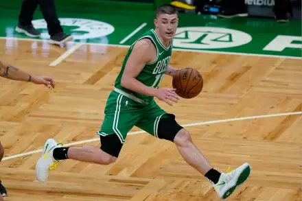Payton Pritchard of the Boston Celtics dribbles the basketball during a game, showcasing his athleticism on the hardwood floor in this vibrant 4K Ultra HD wallpaper.