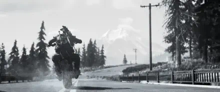 A black and white scene from the video game Days Gone, featuring a rider on a motorcycle kicking up dirt on a remote road with mountains in the background. 4K Ultra HD wallpaper.