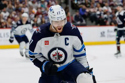 HD hockey wallpaper featuring a Winnipeg Jets NHL player in action on the ice during a game, showcasing intense sportsmanship and team spirit.