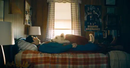 HD PC desktop wallpaper featuring a cozy scene from Superman (2025) with Krypto, the loyal dog from DC Comics, resting together on a bed in a warmly lit room.