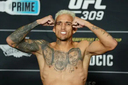 UFC fighter Charles Oliveira flexes his arms confidently at a weigh-in event, featured in an HD PC desktop wallpaper and background.