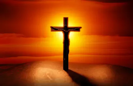 HD desktop wallpaper of Jesus on the cross silhouetted against a fiery sunset, a Bible-inspired religious crucifixion scene.
