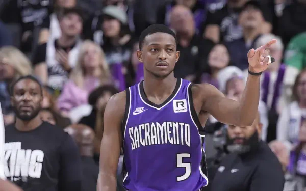 De'Aaron Fox of the Sacramento Kings gestures to fans during an NBA game, showcasing his skill and determination. A dynamic HD wallpaper for basketball enthusiasts.