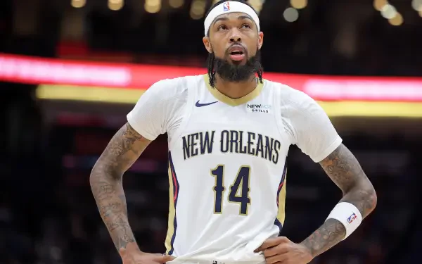 Brandon Ingram of the New Orleans Pelicans stands on the court in his team uniform, focused and ready during an NBA game, showcased in a stunning 4K Ultra HD wallpaper.