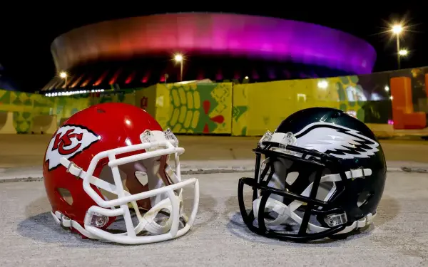 A vibrant HD wallpaper featuring Kansas City Chiefs and Philadelphia Eagles football helmets, set against a backdrop of an illuminated stadium, capturing the excitement of NFL sports.