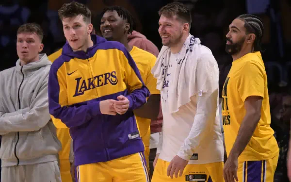 A vibrant HD wallpaper featuring Luka Dončić and Austin Reaves alongside teammates in Los Angeles Lakers jerseys, showcasing camaraderie on the basketball court.