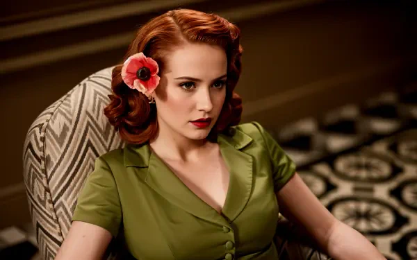 A stylish woman with red hair and a flower in her hair sits elegantly in a patterned chair, captured in a vintage-inspired 4K Ultra HD wallpaper.