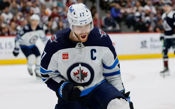 HD hockey wallpaper featuring a Winnipeg Jets NHL player in action on the ice during a game, showcasing intense sportsmanship and team spirit.