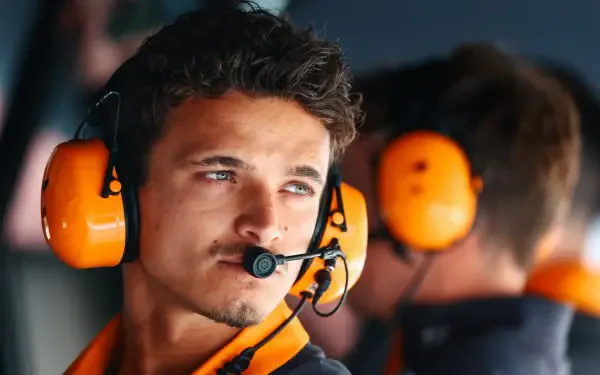 Close-up of F1 driver Lando Norris wearing a headset, captured in an HD PC desktop wallpaper and background.