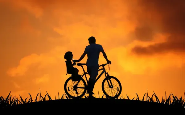 HD PC desktop wallpaper background: family silhouette of a parent and child on a bicycle against an orange sunset.