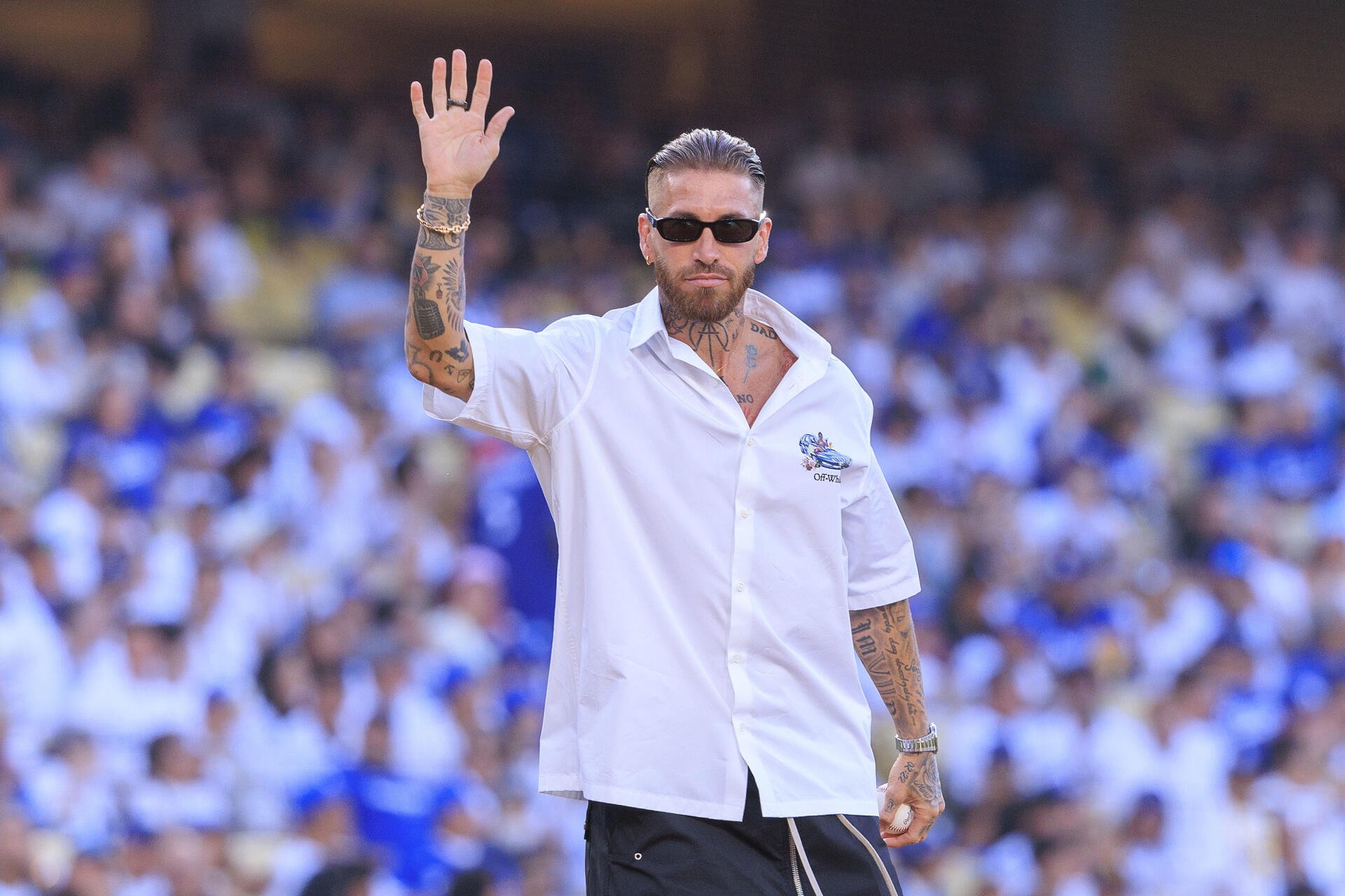 HD PC desktop wallpaper of a bearded, tattooed footballer in sunglasses waving to a cheering crowd in a packed stadium.