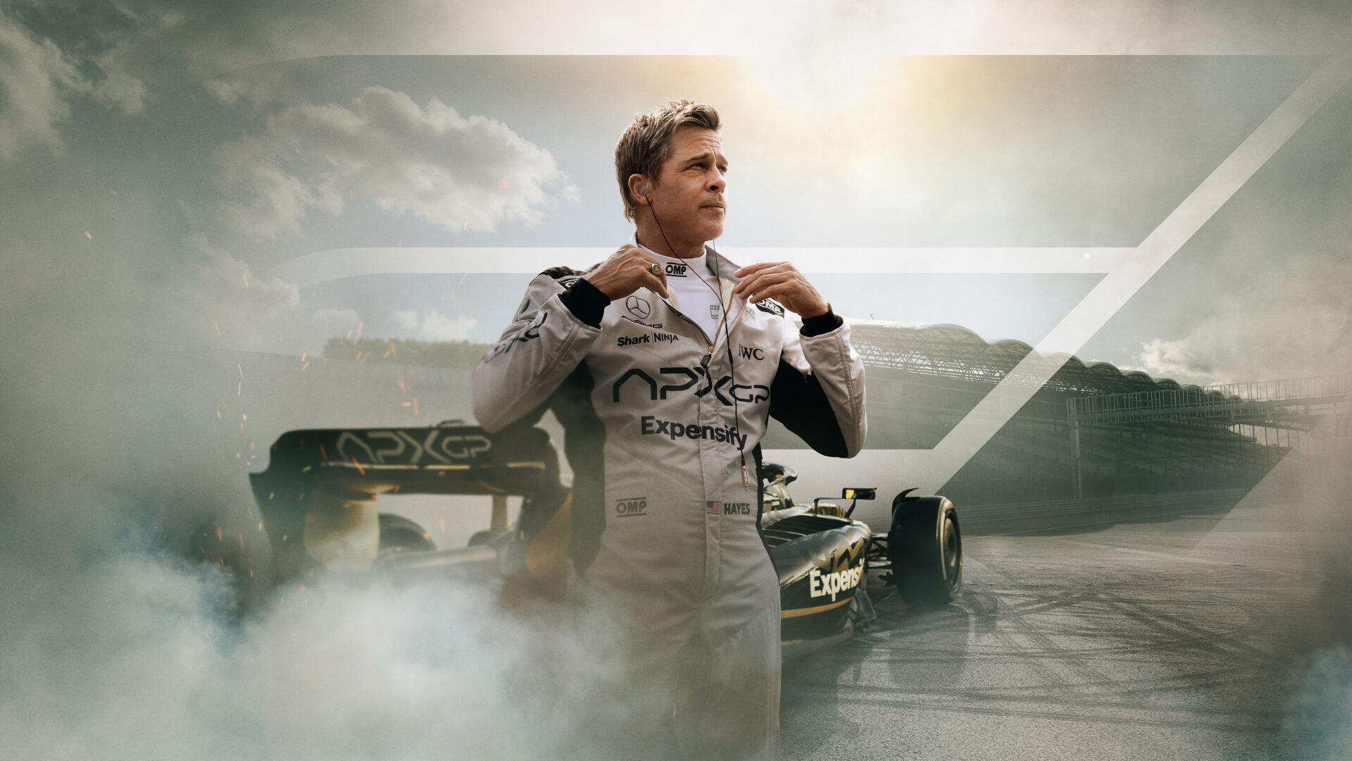 F1 (2025) 4K Ultra HD PC desktop wallpaper/background: race driver in suit adjusting his collar beside a smoke-wreathed Formula 1 car on a dramatic racetrack at sunrise.