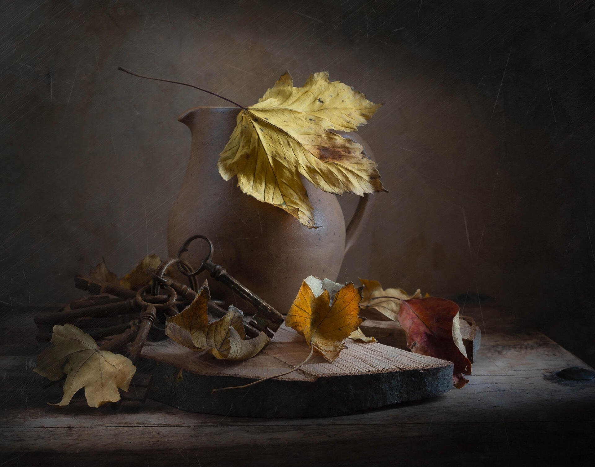 HD PC desktop wallpaper/background: vintage still life of an old iron key and autumn leaves on a worn wooden surface in muted retro tones.