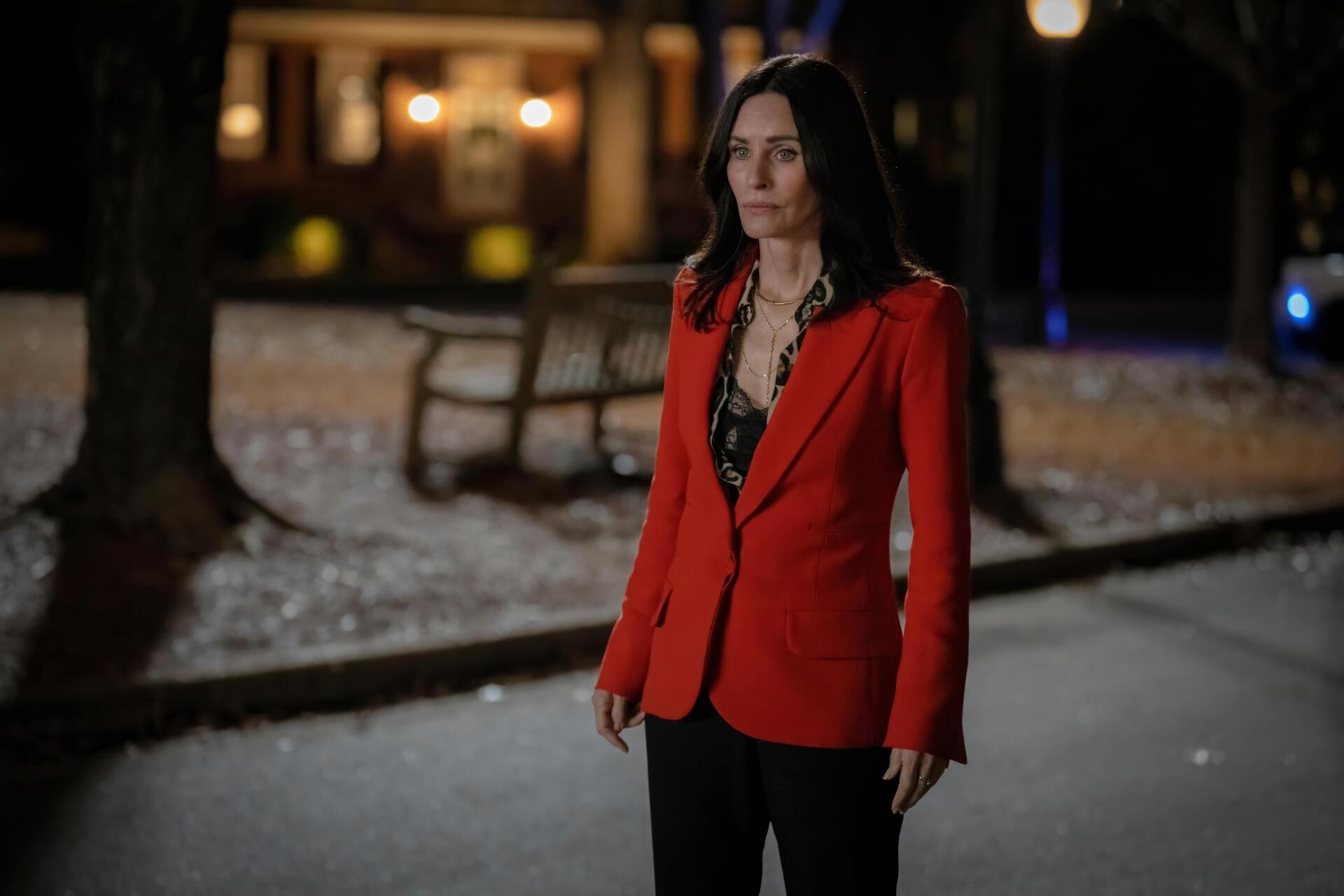 4K Ultra HD PC desktop wallpaper/background: woman in a red blazer and black lace top stands on a snowy, dimly lit park path with warm house lights blurred behind.