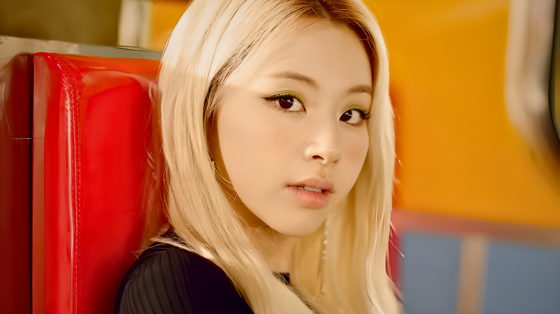 4K Ultra HD desktop wallpaper: portrait of a blonde K-pop idol/model in 80s-inspired styling, seated in a retro diner with warm orange and red tones.