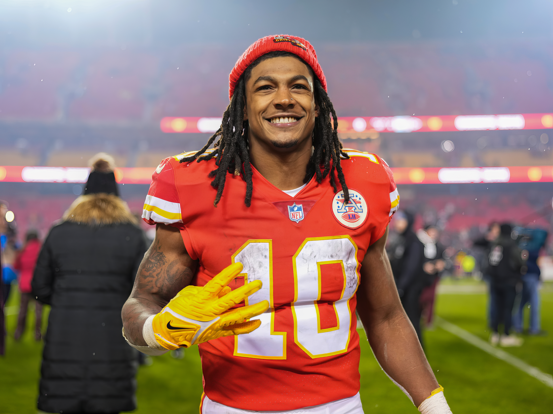 Smiling Kansas City Chiefs football player with dreadlocks wearing a red #10 jersey on the field — HD desktop wallpaper background.