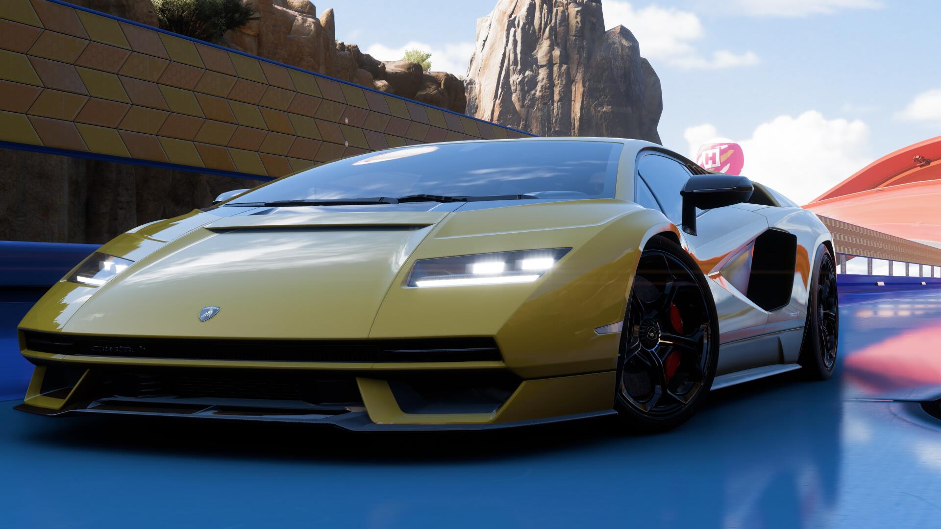 4K Ultra HD PC desktop wallpaper background from the video game Forza Horizon 5: yellow Lamborghini Countach, low-angle close-up on a sunlit track with glossy finish and motion blur.