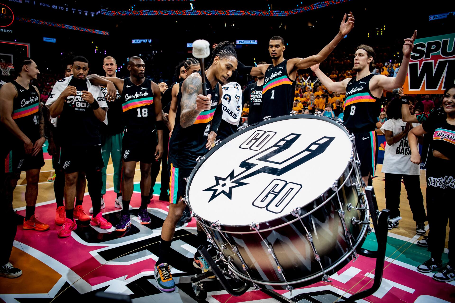 4K Ultra HD PC desktop wallpaper: NBA basketball San Antonio Spurs team circling a giant drum on the court, celebrating in colorful alternate jerseys.