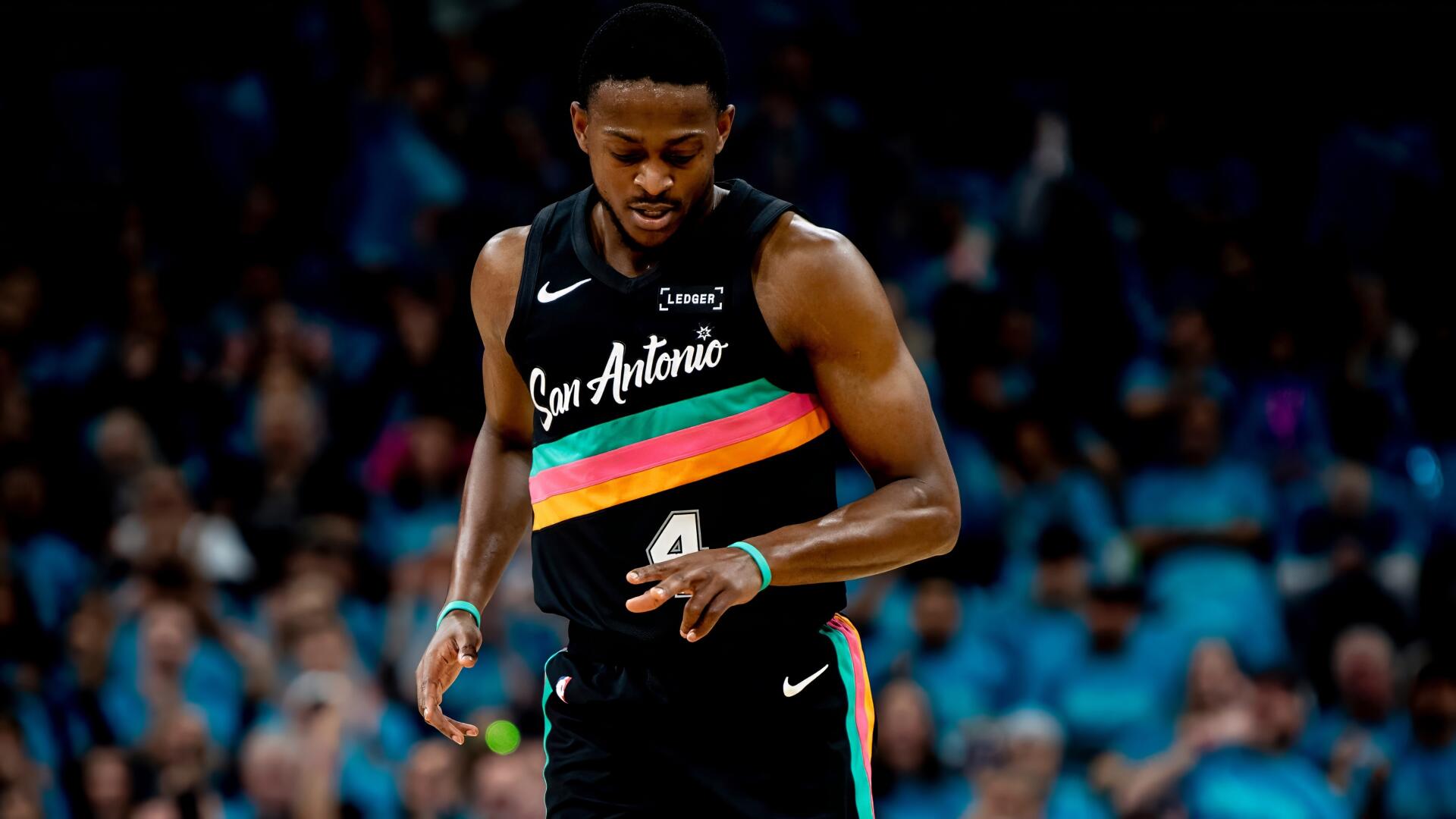 NBA basketball player in San Antonio Spurs black rainbow jersey dribbling down the court — bold 2K Quad HD PC desktop wallpaper/background.